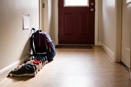 A school bag and shoes set ready by the front door of an Australian home early in the morning.