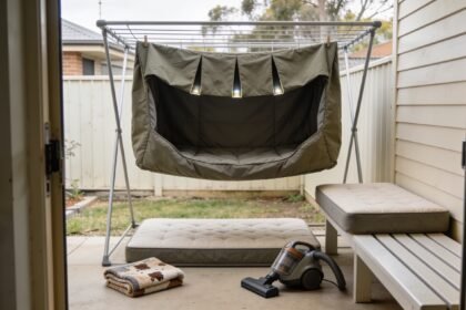 A dog bed cover drying on a rack beside its separate foam inner and a folded blanket.