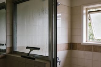A bathroom with the window open and condensation clearing from the mirror after a shower.