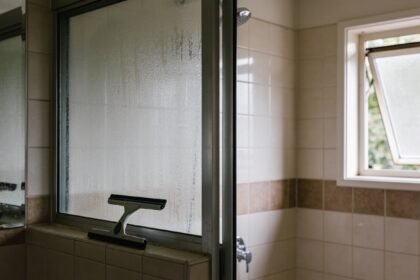 A bathroom with the window open and condensation clearing from the mirror after a shower.