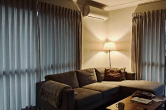 An Australian living room in winter with curtains drawn and a wall-mounted reverse cycle unit.