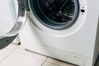 The open door and rubber seal of a front loading washing machine, with the empty drum visible behind.