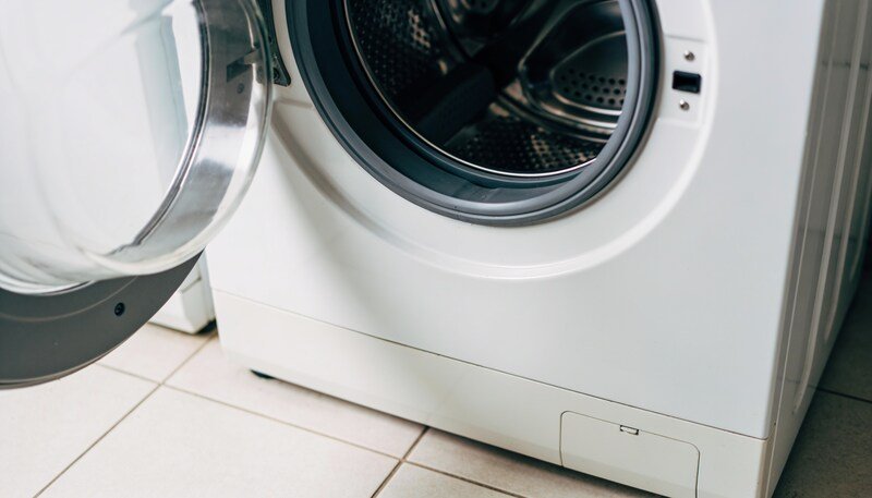 The open door and rubber seal of a front loading washing machine, with the empty drum visible behind.