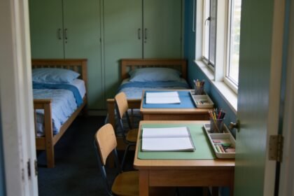 Two compact desks with separate work trays and chairs in a bedroom shared by two children.